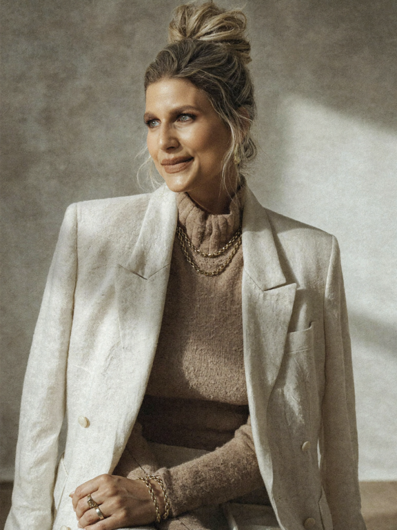 Melissa Goodwin in a cream blazer and camel turtleneck